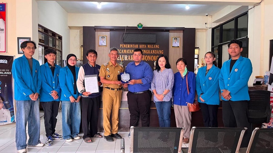 Momen penyerahan cendera mata dari Ketua Tim Abdimas ITN Malang, Deddy Rudhistiar, kepada Lurah Wonokoyo, Bagus Vavan Setiawan di balai kelurahan